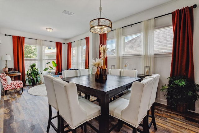 dining room featuring visible vents, wood finished floors, and a chandelier
