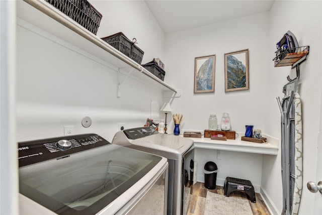 laundry room with separate washer and dryer, laundry area, baseboards, and light wood-type flooring