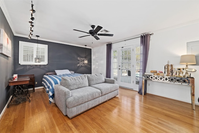 bedroom featuring track lighting, access to exterior, wood finished floors, visible vents, and ornamental molding