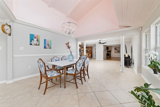 dining space with baseboards, ornate columns, ceiling fan with notable chandelier, light tile patterned floors, and vaulted ceiling