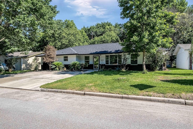 single story home featuring roof with shingles, driveway, and a front lawn