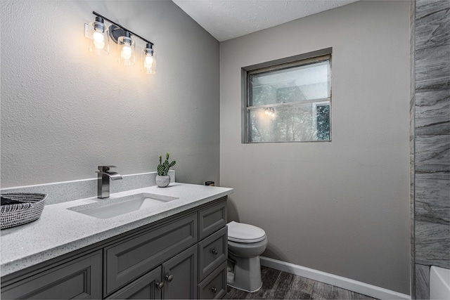 full bath featuring vanity, baseboards, wood finished floors, and toilet