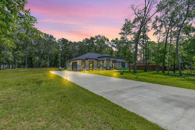 view of community with a lawn, a garage, and concrete driveway