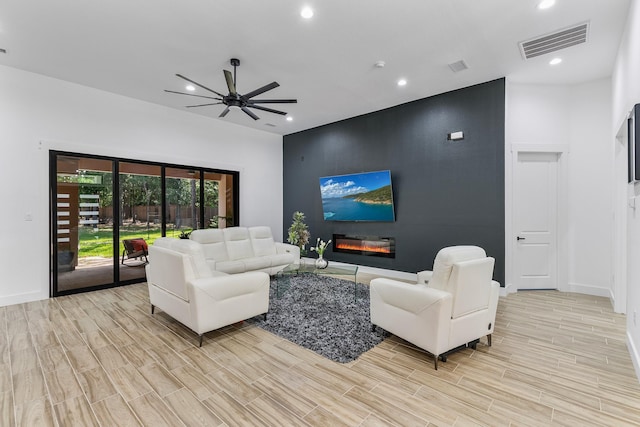 living room with visible vents, baseboards, light wood-style floors, ceiling fan, and recessed lighting