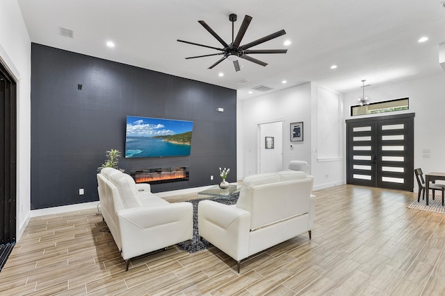 living area featuring recessed lighting, baseboards, visible vents, and light wood finished floors
