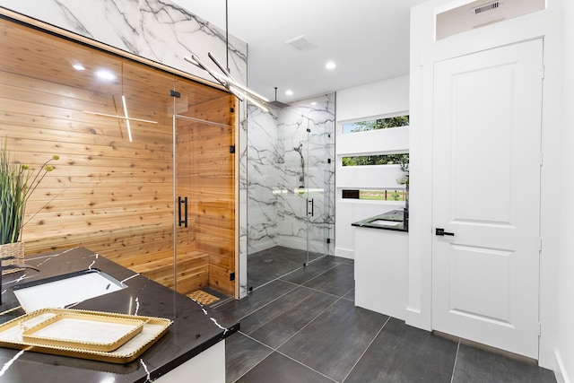 full bathroom with a marble finish shower, recessed lighting, and visible vents