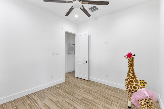interior space featuring baseboards, a ceiling fan, light wood-type flooring, and visible vents