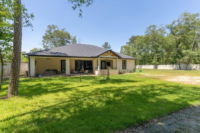back of property featuring fence private yard, ceiling fan, and a yard