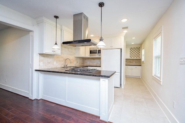1406 Foxwood Rd, Houston, TX 77008 - kitchen with gas cooktop, island exhaust hood, a sink, freestanding refrigerator, and dark stone countertops