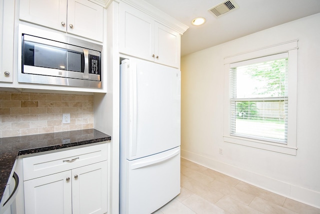 1406 Foxwood Rd, Houston, TX 77008 - kitchen featuring backsplash, visible vents, baseboards, freestanding refrigerator, and stainless steel microwave