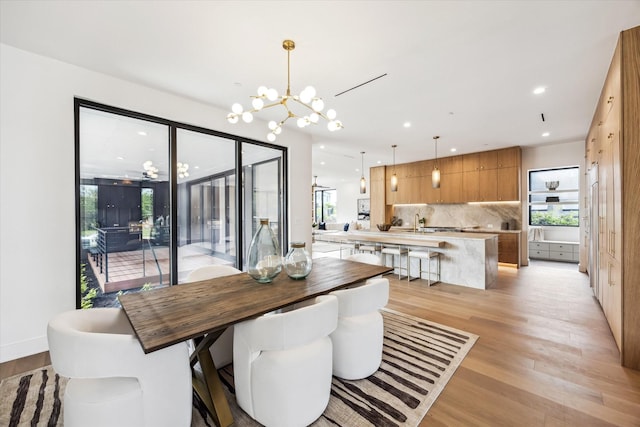 dining space with an inviting chandelier, recessed lighting, light wood finished floors, and plenty of natural light