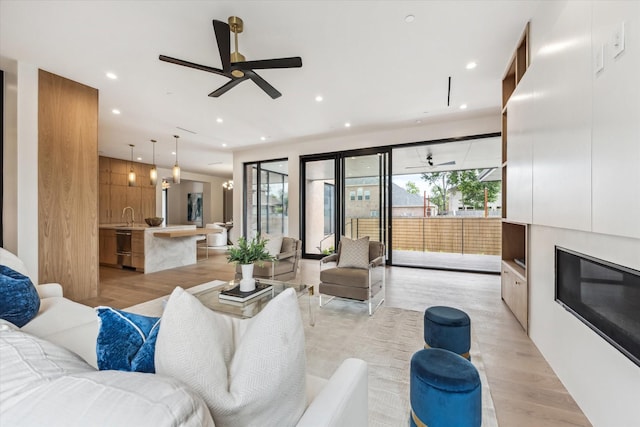 living room featuring recessed lighting, ceiling fan, and light wood finished floors