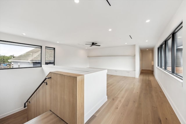 interior space featuring recessed lighting, light wood-style flooring, and an upstairs landing