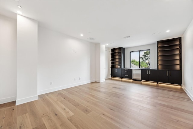 unfurnished living room featuring visible vents, baseboards, recessed lighting, bar, and light wood finished floors