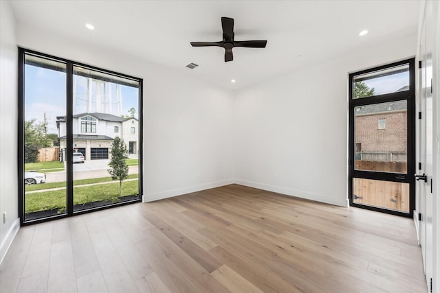 unfurnished room featuring ceiling fan, light wood-type flooring, and a wealth of natural light
