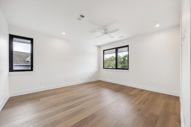 unfurnished room with visible vents, a ceiling fan, light wood-style flooring, and baseboards