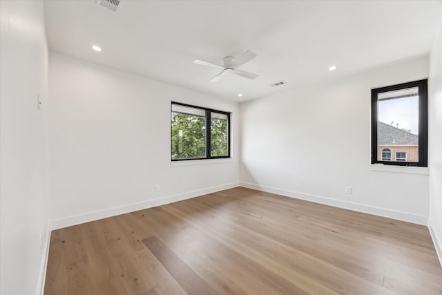 unfurnished room featuring baseboards, visible vents, ceiling fan, and light wood-style floors