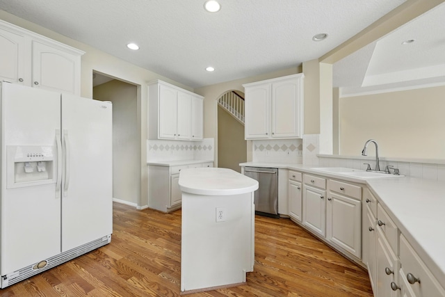 11030 Sprucedale Ct, Houston, TX 77070 - kitchen featuring white fridge with ice dispenser, dishwasher, a sink, white cabinets, and backsplash
