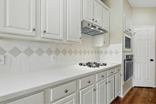 11030 Sprucedale Ct, Houston, TX 77070 - kitchen with stainless steel oven, white gas cooktop, under cabinet range hood, white cabinetry, and dark wood-style floors