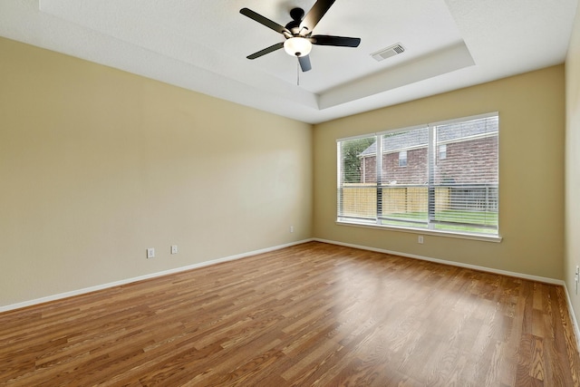 11030 Sprucedale Ct, Houston, TX 77070 - empty room featuring wood finished floors, a tray ceiling, a ceiling fan, and baseboards
