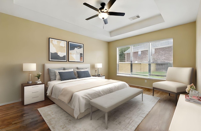 11030 Sprucedale Ct, Houston, TX 77070 - bedroom featuring a tray ceiling, baseboards, dark wood-type flooring, and a ceiling fan