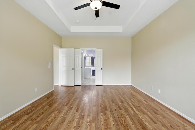 11030 Sprucedale Ct, Houston, TX 77070 - spare room with a tray ceiling, wood finished floors, ceiling fan, and baseboards