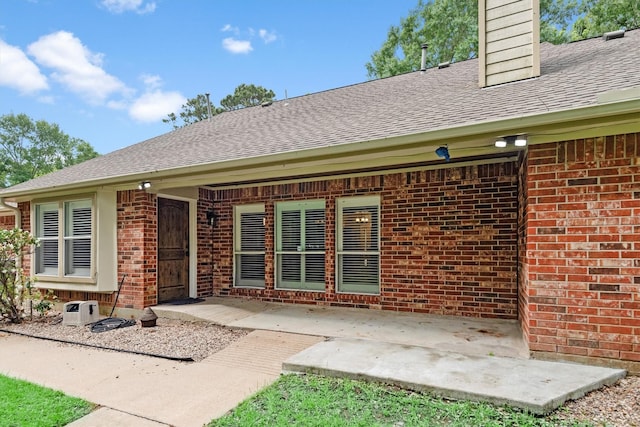 230009 Kama Dr, Porter, TX 77365 - back of property with brick siding, roof with shingles, a chimney, and a patio