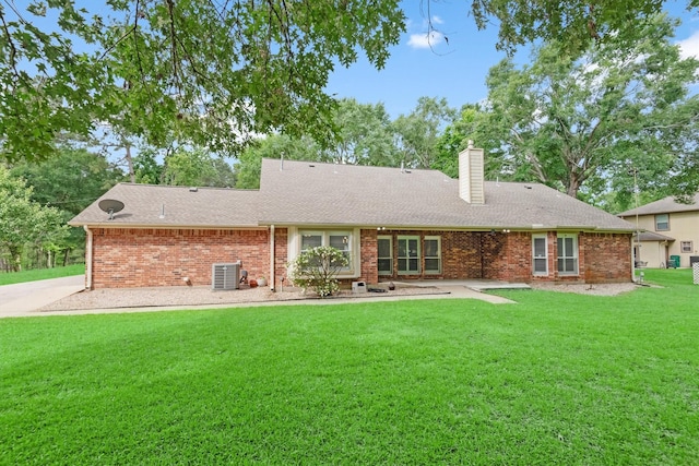 230009 Kama Dr, Porter, TX 77365 - rear view of house with a shingled roof, brick siding, a chimney, central air condition unit, and a yard