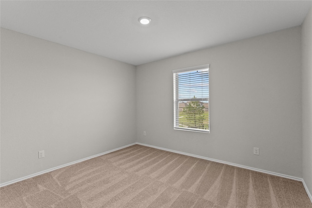 carpeted empty room featuring baseboards