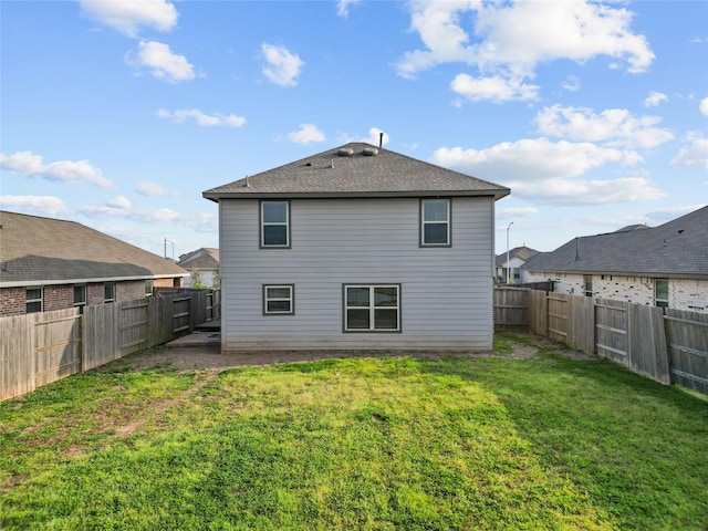 back of property featuring a lawn and a fenced backyard