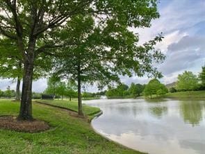 view of home's community featuring a lawn and a water view