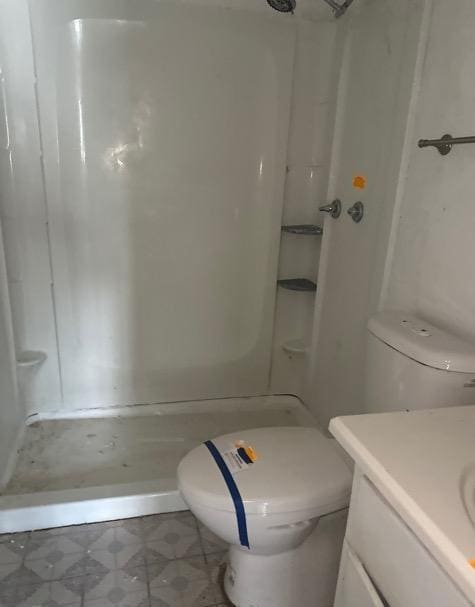 full bath with vanity, toilet, and a stall shower