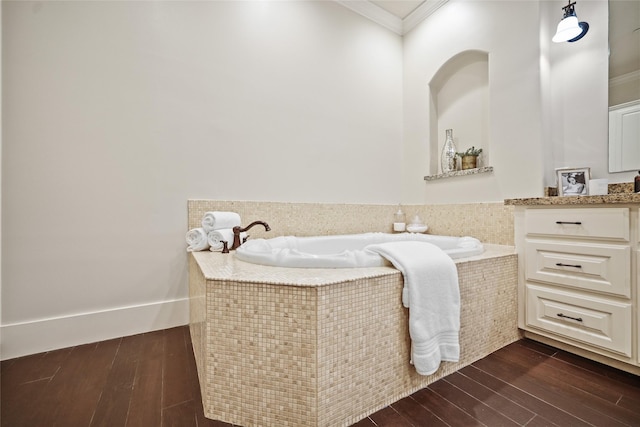 full bathroom featuring ornamental molding, wood finished floors, a bath, and vanity