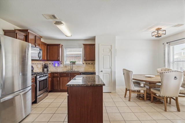 kitchen with a healthy amount of sunlight, decorative backsplash, visible vents, a sink, and stainless steel appliances
