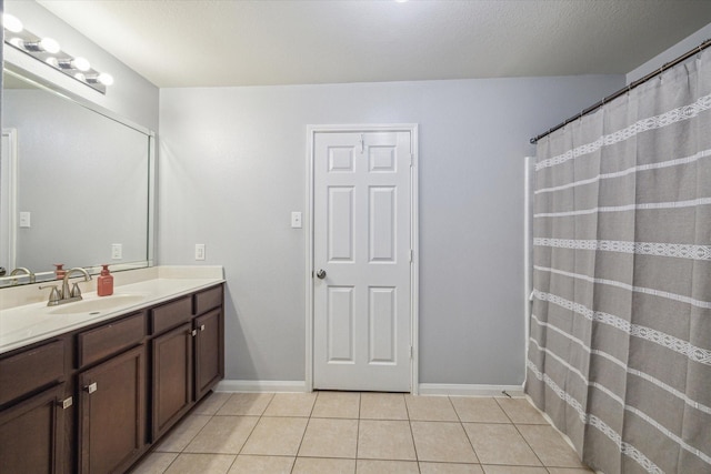 full bathroom with tile patterned floors, baseboards, and vanity