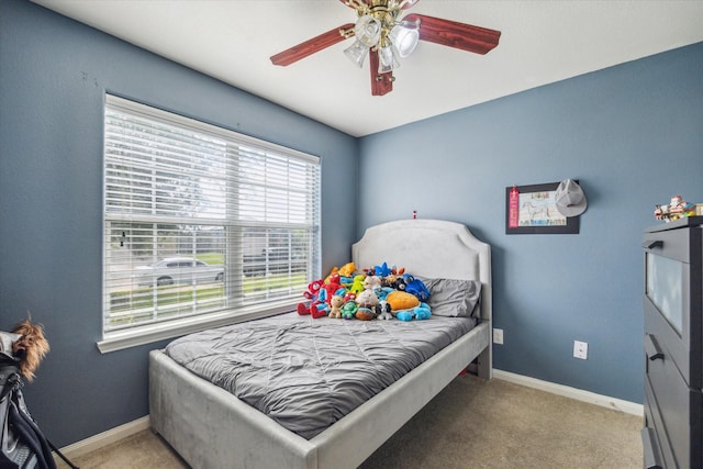 carpeted bedroom featuring baseboards and a ceiling fan