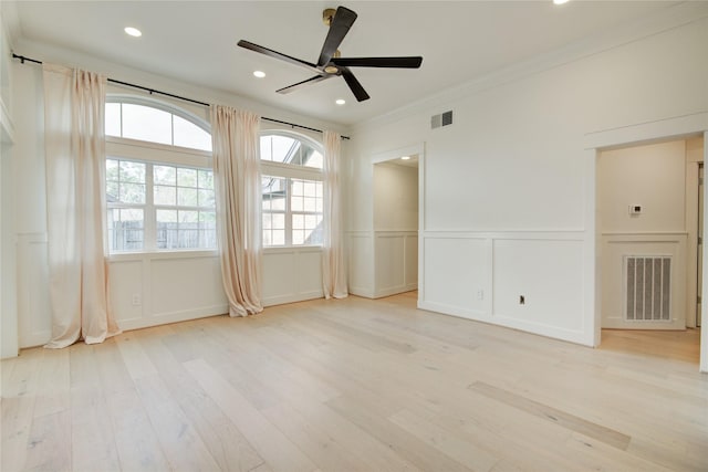 unfurnished room with a decorative wall, visible vents, and light wood-type flooring