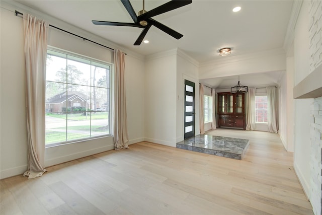entrance foyer featuring crown molding, plenty of natural light, and light wood finished floors