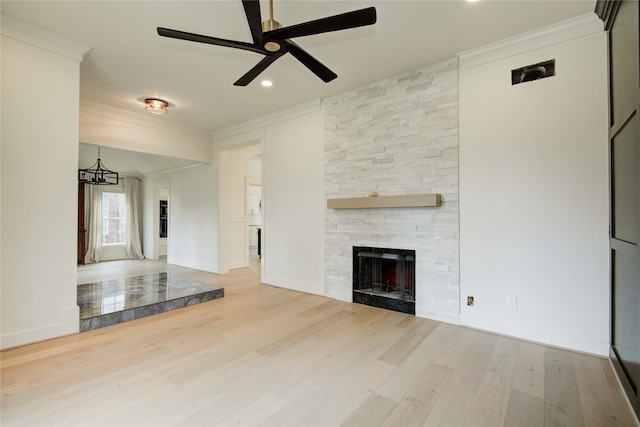 unfurnished living room with crown molding, ceiling fan, wood finished floors, and a fireplace