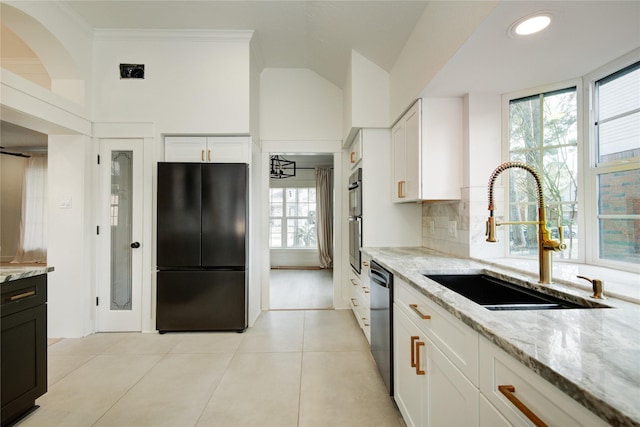 kitchen with a sink, white cabinetry, black appliances, and light stone countertops