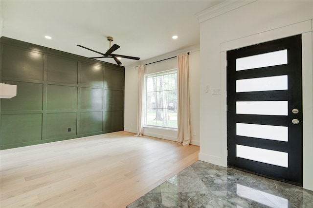 entryway with recessed lighting, a ceiling fan, baseboards, and a decorative wall