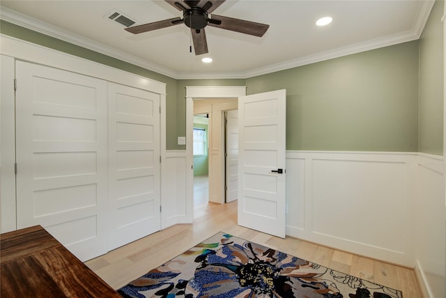 unfurnished bedroom featuring visible vents, crown molding, wainscoting, light wood finished floors, and recessed lighting