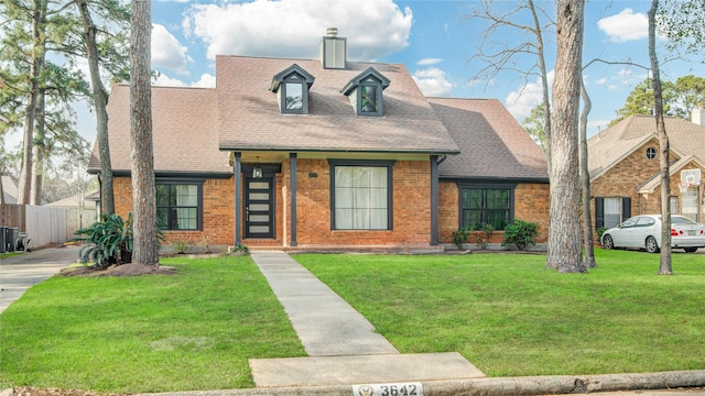 view of front facade featuring brick siding, central AC unit, a front lawn, and fence