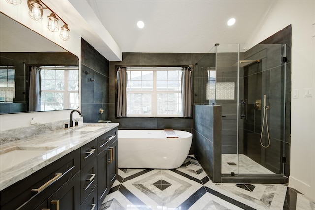 bathroom with a freestanding bath, a sink, double vanity, recessed lighting, and a shower stall