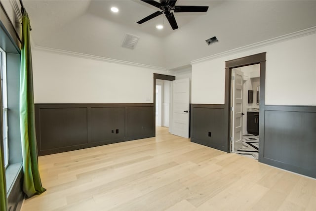 spare room featuring crown molding, wainscoting, and visible vents