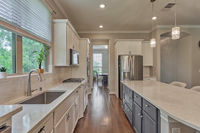 kitchen featuring gray cabinetry, a sink, white cabinets, and a wealth of natural light
