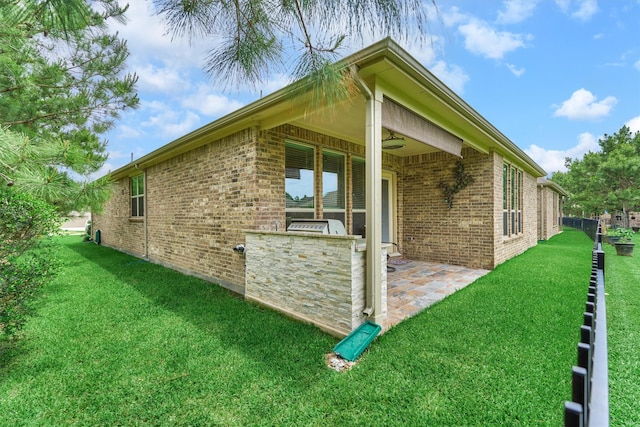 view of home's exterior with an outdoor kitchen, a yard, and brick siding