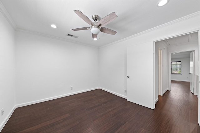 unfurnished room with visible vents, attic access, baseboards, and dark wood-type flooring