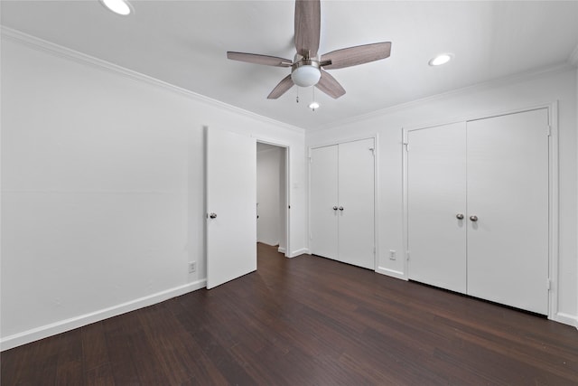 unfurnished bedroom featuring wood finished floors, baseboards, multiple closets, ornamental molding, and recessed lighting