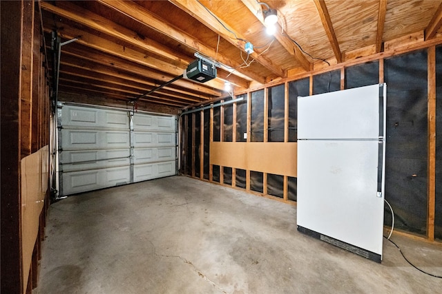 garage with a garage door opener and freestanding refrigerator